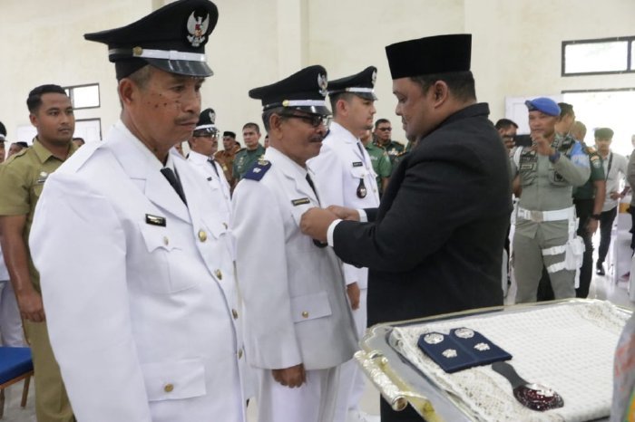 Sekdakab Aceh Besar, Drs. Sulaimi, M.Si memasang tanda jabatan simbolis kepada tiga Keuchik hasil Pilchiksung Aceh Besar 2023 di Gedung SKB Kota Jantho, Aceh Besar, Senin (30/10/2023).