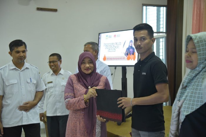 Pj Ketua Dewan Kerajinan Nasional Daerah (Dekranasda) Aceh Besar, Cut Rezky Handayani, SIP, MM, menyerahkan tas secara simbolis kepada peserta pembinaan dan peningkatan industri gerabah untuk Warga Lamche di Gedung Dekranasda Aceh Besar.