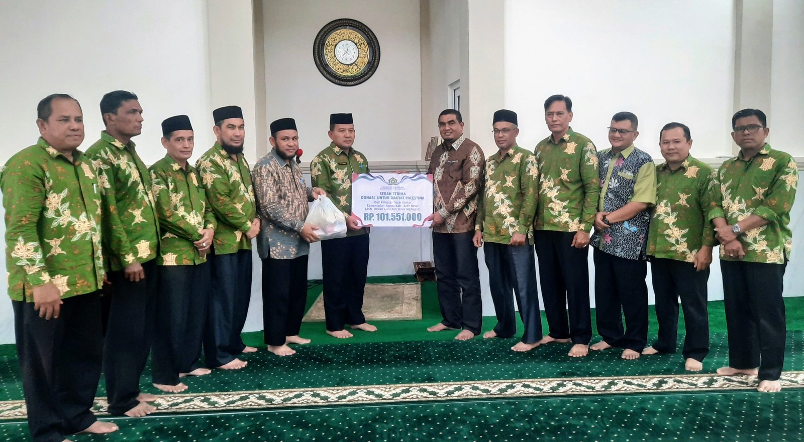 Kepala Kantor Kementerian Agama Kabupaten Aceh Besar H Saifuddin SE menyerahkan Donasi Bantuan Kemanusian untuk Palestina yang diterima langsung Kakanwil Kemenag Aceh Drs H Azhari SE yang berlangsung di Mushalla Al Ikhlas Kanwil Kemenag Aceh.