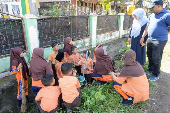Sekdakab Aceh Besar, Drs Sulaimi MSi bersama istri berdialog dengan murid sekolah dalam kegiatan aksi 1 jam memingut sampah dalam memperingati Hari Guru Nasional Tahun 2023 di Sekolah Dasar Negeri (SDN) Lemreung, Kecamatan Kreung Barona Jaya, Aceh Besar,