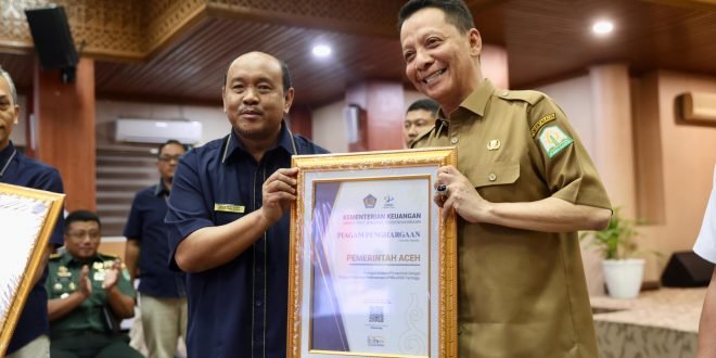 Penjabat Gubernur Aceh Achmad Marzuki, menerima penghargaan atas capaian sebagai Instansi Pemerintah dengan Tingkat Kolaborasi Pelaksanaan APBN - APBD Tertinggi dari Kepala Kanwil DJPb Provinsi Aceh Izharul Haq di Kantor Gubernur Aceh, Banda Aceh, Selasa, (5/12/2023).