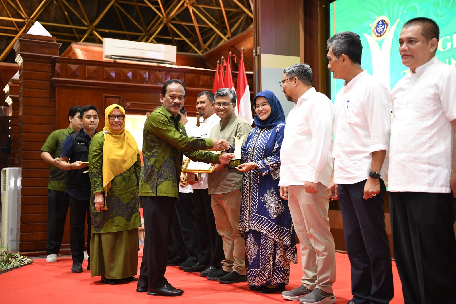 Asisten Bidang Perekonomian dan Pembangunan Sekda Aceh, Mawardi, mewakili Pj Gubernur Aceh menyerahkan penghargaan untuk Satuan Kerja Perangkat Aceh (SKPA) yang melahirkan kebijakan dan program inovatif dalam acara Anugerah Inovasi Aceh, di Anjong Mon Mata Komplek Meuligoe Gubernur, Jumat, 8 Desember 2023. Foto : Humas Pemerintah Aceh