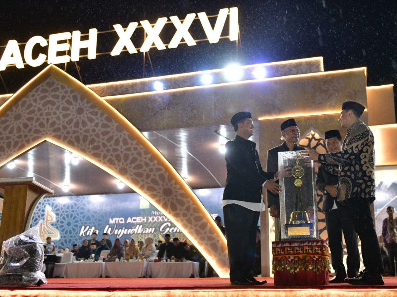 Sekdako Banda Aceh Wahyudi menerima langsung Piala Bergilir Juara Umum MTQ dari Kepala Dinas Syariat Islam Aceh Zahroel Fajri yang mewakil Pj Gubernur Aceh pada malam penutupan MTQ Aceh di Lapangan Pendopo Bupati Simeulue. Foto : Pemko Banda Aceh