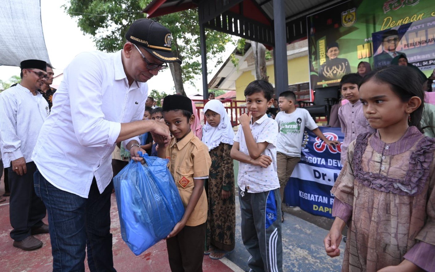 Anggota DPRK Banda Aceh Dr Musriadi SPd MPd memberikan bantuan seragam sekolah komplit kepada siswa tingkat SD, dan SMP kurang mampu di Kecamatan Ulee Kareng.