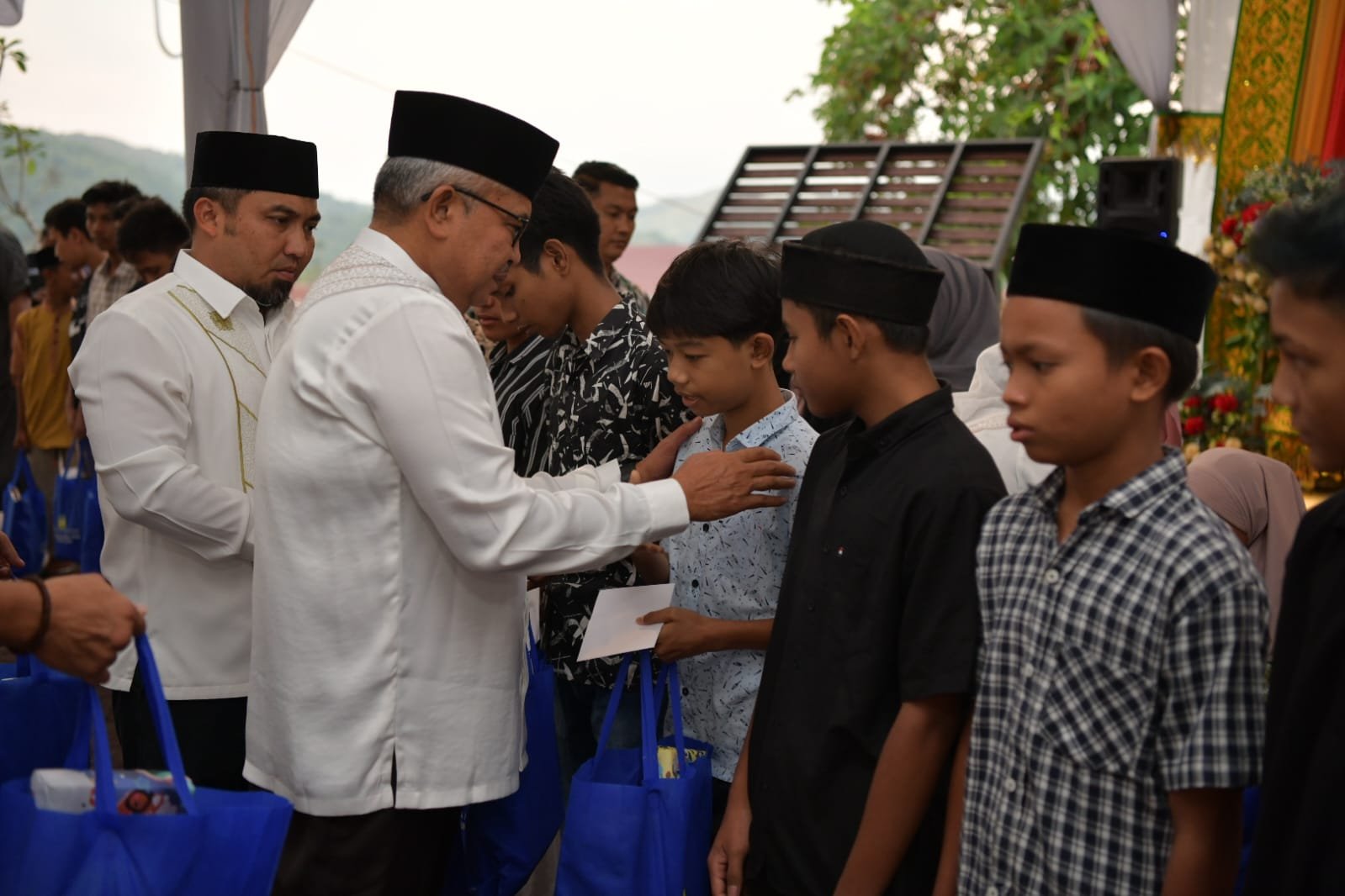 Pj. Gubernur Aceh, Bustami bersama Pj. Ketua PKK Aceh, Mellani Subarni disambut Pj. Bupati Aceh Besar, Muhammad Iswanto saat menghadiri Buka puasa bersama sekaligus Peusijuk serta Santunan Kepada Anak Yatim di Pendopo Bupati Aceh Besar, Kota Jantho, Aceh Besar, Kamis, 21 Maret 2024.