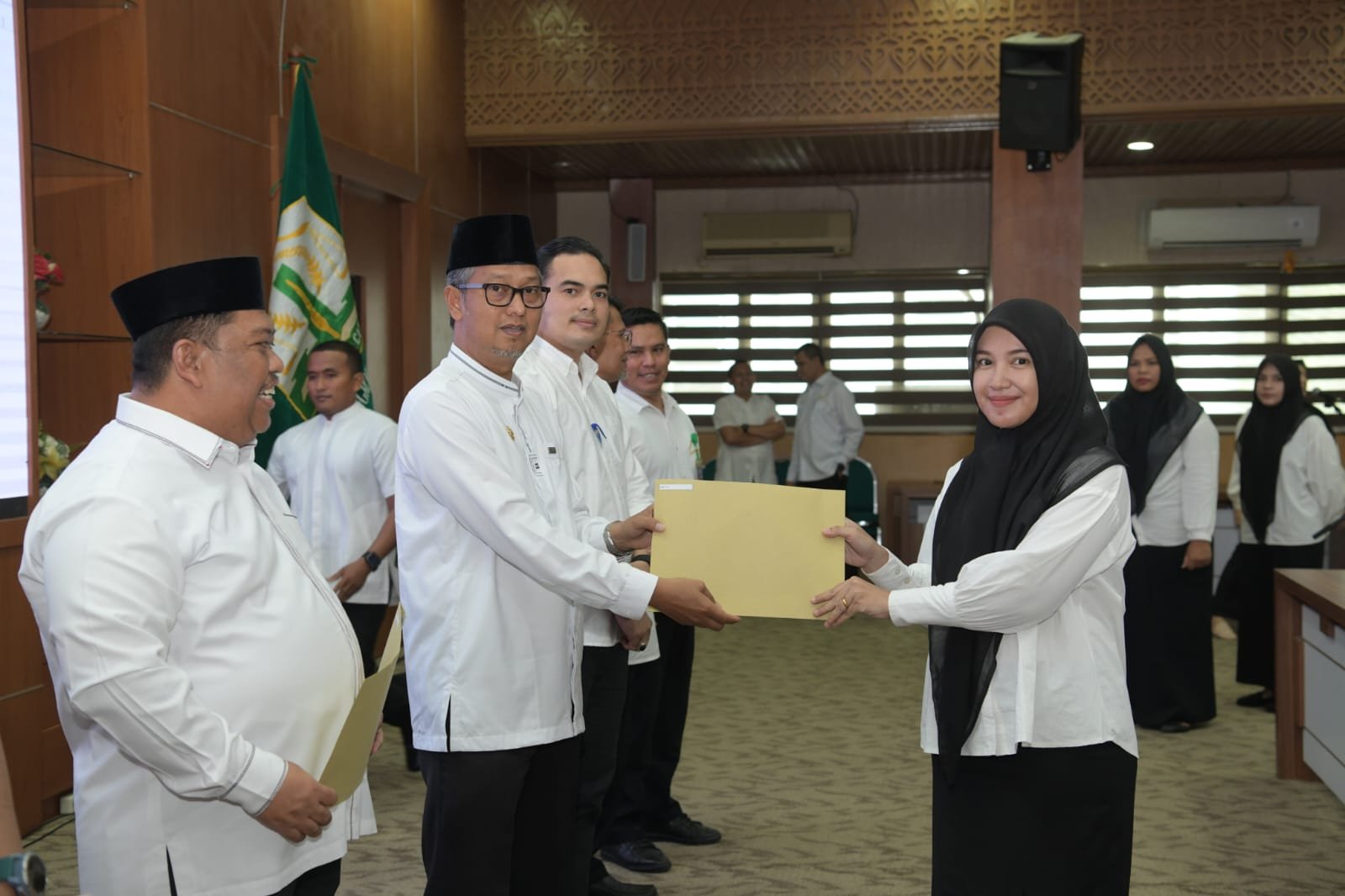 Asisten Administrasi Umum Sekda Aceh Dr. H. Iskandar AP, S.Sos. M.Si menyerahkan Sk tenaga kontrak kepada salah satu tenaga kontrak pada biro Adpim di gedung serbaguna Kantor Gubernur, Jum'at, 22 Maret 2024.