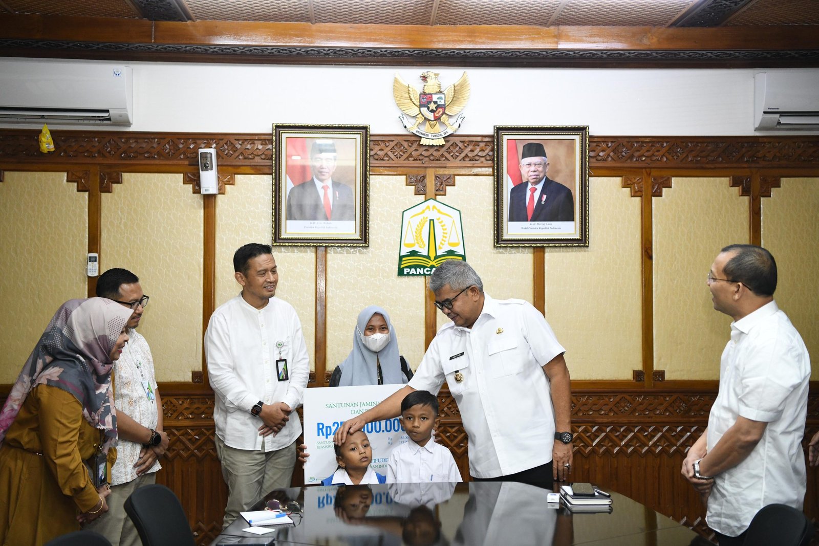 Pj Gubernur Aceh Bustami, SE, M.Si didampingi Direktur Keuangan BPJS Ketenagakerjaan, menyerahkan Santunan Jaminan Kematian dan Beasiswa kepada kepada Istri dan Anak Almarhum Yusri Afifuddin di Ruang Rapat Gubernur Aceh. Jumat, 22 Maret 2024.