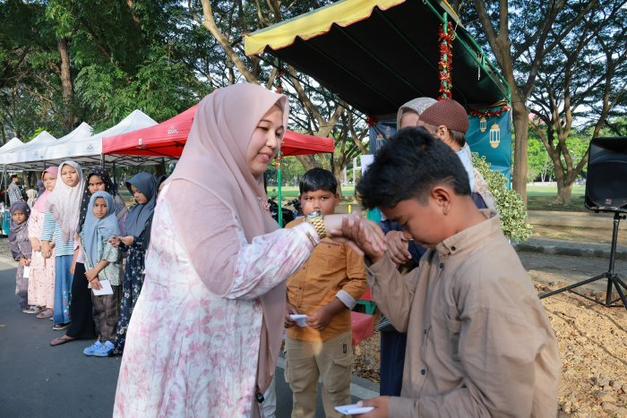 Ketua TP PKK Aceh Besar, Rita Mayasari, menyantuni anak yatim di arena EXSIS Ramadhan Universitas Syiah Kuala di lapangan gelanggang Darussalam, Banda Aceh, Selasa (18/03/2025). FOTO/MC ACEH BESAR BESAR